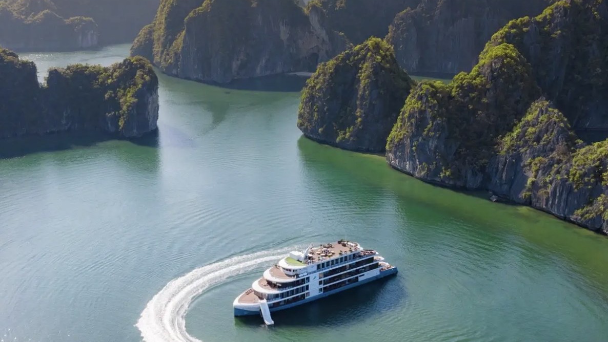 A ship at anchor among limestone islands, seen from the air